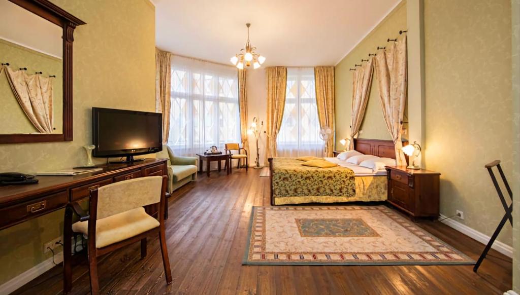 塔林Taanilinna Hotell的客房设有床、书桌和电视。