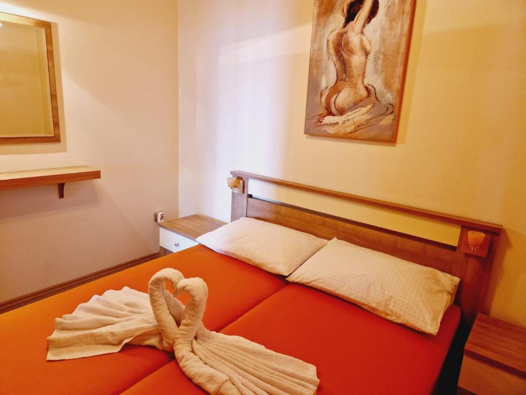 塞尼Guest House Sombrero 2的一间卧室配有橙色床,上面有毛巾