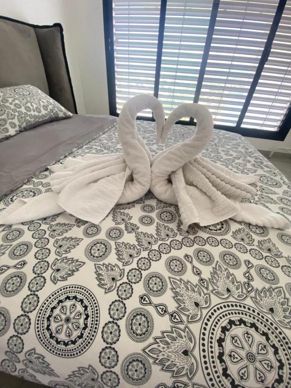 卡梅尔studio ilanit的床上的两条毛巾天鹅