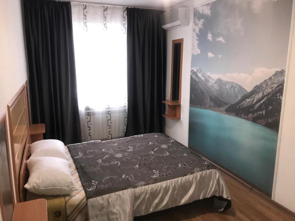 阿拉木图Apartments on Koktem 1的一间卧室设有一张床和一个享有山景的窗户。