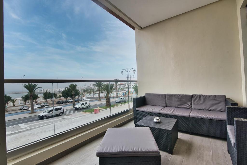 阿加迪尔New Sea Front Apartment 135mq with Unlimited Wi-Fi的带沙发和大窗户的客厅