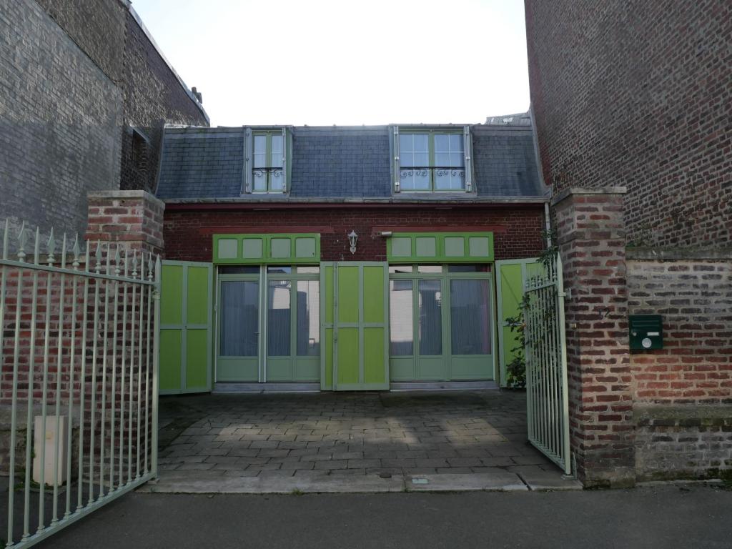 梅尔·莱斯·拜恩斯La Maison Verte 71 m²的砖砌的建筑,设有绿门和门