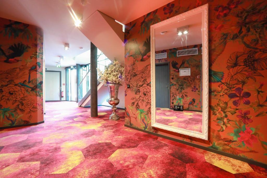 吕本瑙SPREE. Hotel am Hafen的走廊上设有橙色墙壁和大镜子