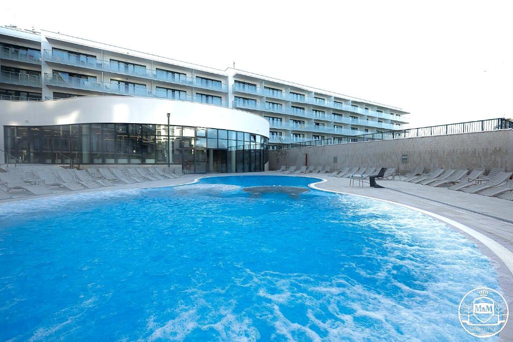 科沃布热格Polanki Aqua - Aquapark, Free Parking, Apartments M&M Kołobrzeg的大楼前方的一大片蓝色海水