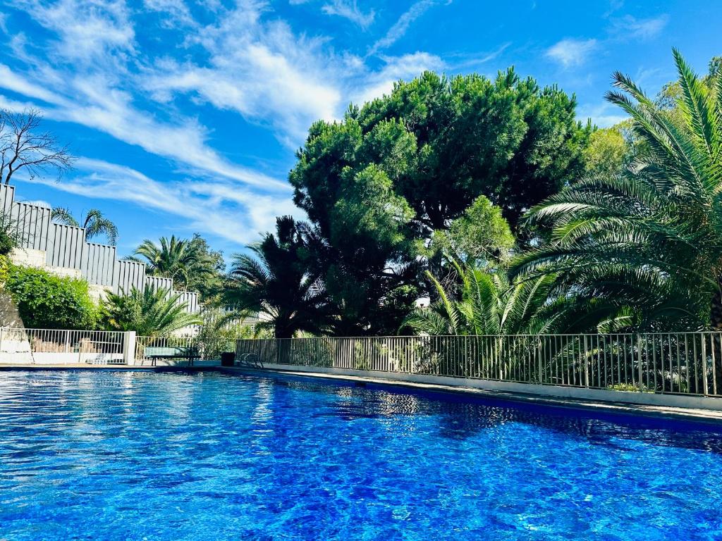 戛纳Luxury 130m2 AC, Terrace, Pool, Parking - Steps to beach, 5 min Palais des Festivals 3BR-3BA的拥有蓝色海水和树木的游泳池