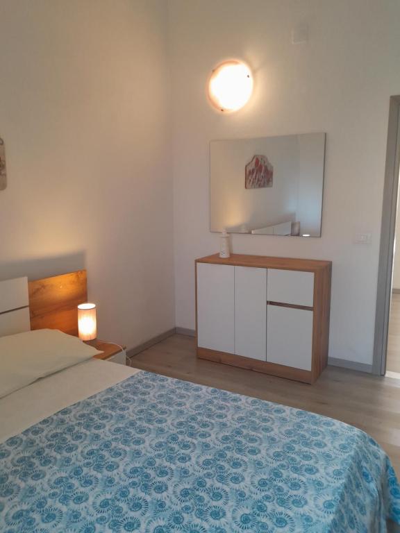 皮昂比诺Casa vicino al mare的一间卧室配有一张床、梳妆台和镜子