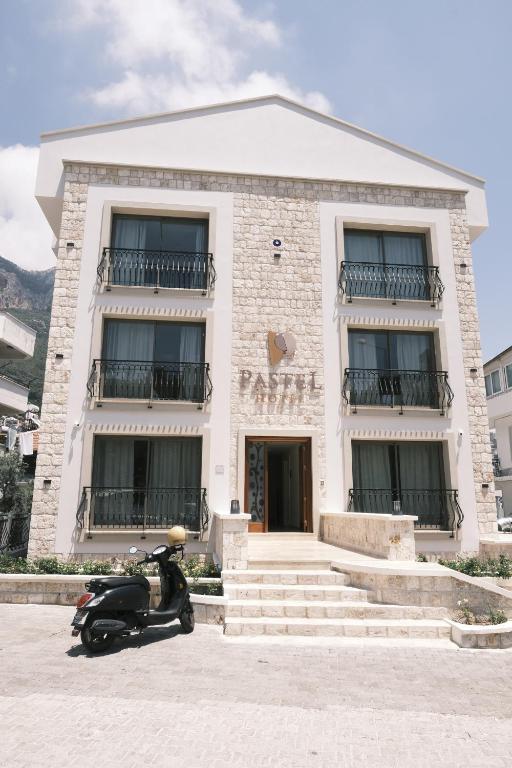 卡斯Hotel Pastel Kaş的停在大楼前的摩托车