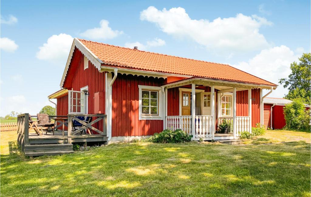 卡尔马Stunning Home In Kalmar With Kitchen的一座红色的房子,有栅栏和院子
