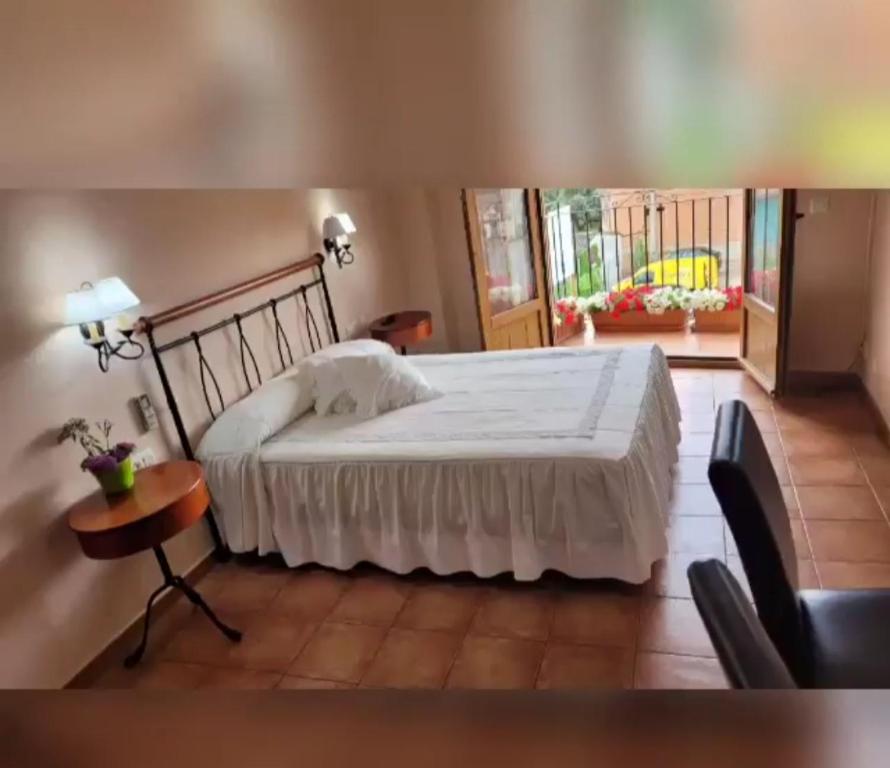CaminomoriscoHotel Rural Cristania的一间卧室配有一张床、一张桌子和一个窗户。