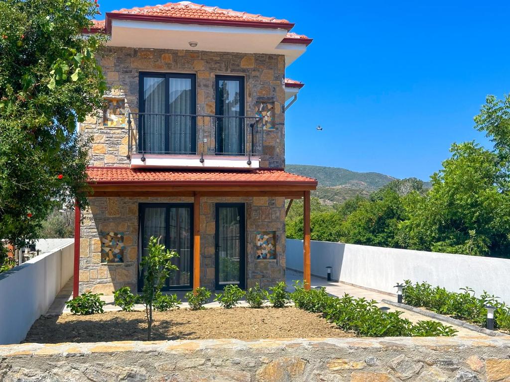 达特恰Villa Seray Datça的砖屋,上面设有阳台