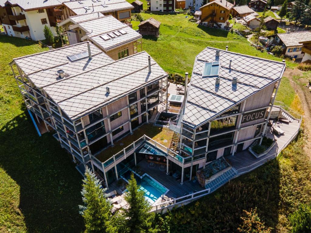 采尔马特Matterhorn FOCUS Design Hotel的享有带游泳池的房屋的空中景致