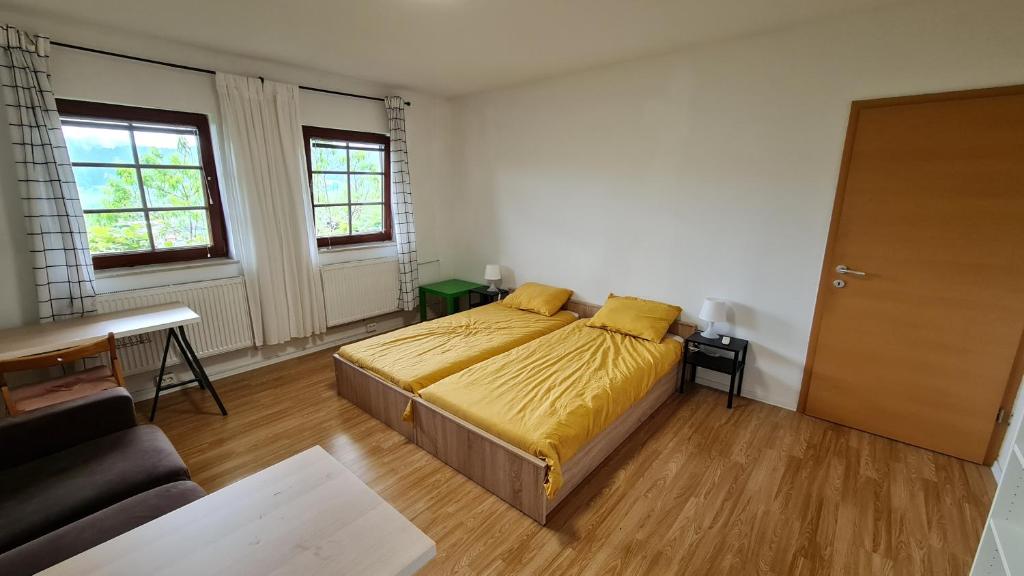 斯洛文尼亚格拉代茨Apartma pri babici的一间卧室配有一张带黄床单的床和一张沙发