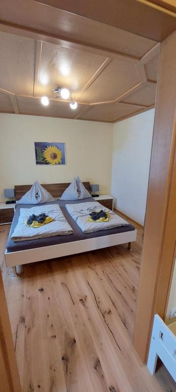 滕嫩山麓圣马丁Appartements Haus Bergland的一间卧室配有一张床,铺有木地板