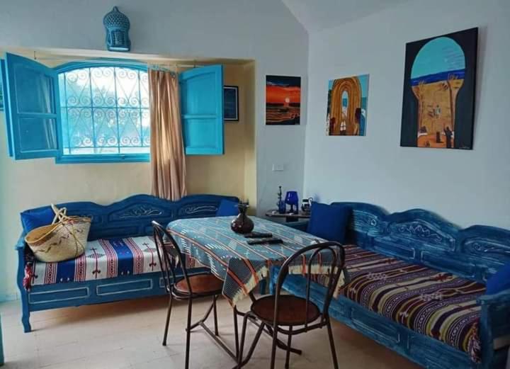 米多恩Bungalow Djerbien的卧室配有一张床和一张桌子及椅子
