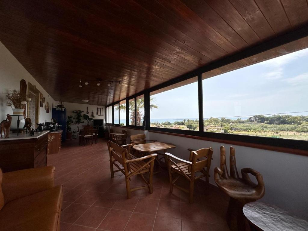 锡库利亚纳La Foggia seaside paradise的一间带桌椅和窗户的用餐室
