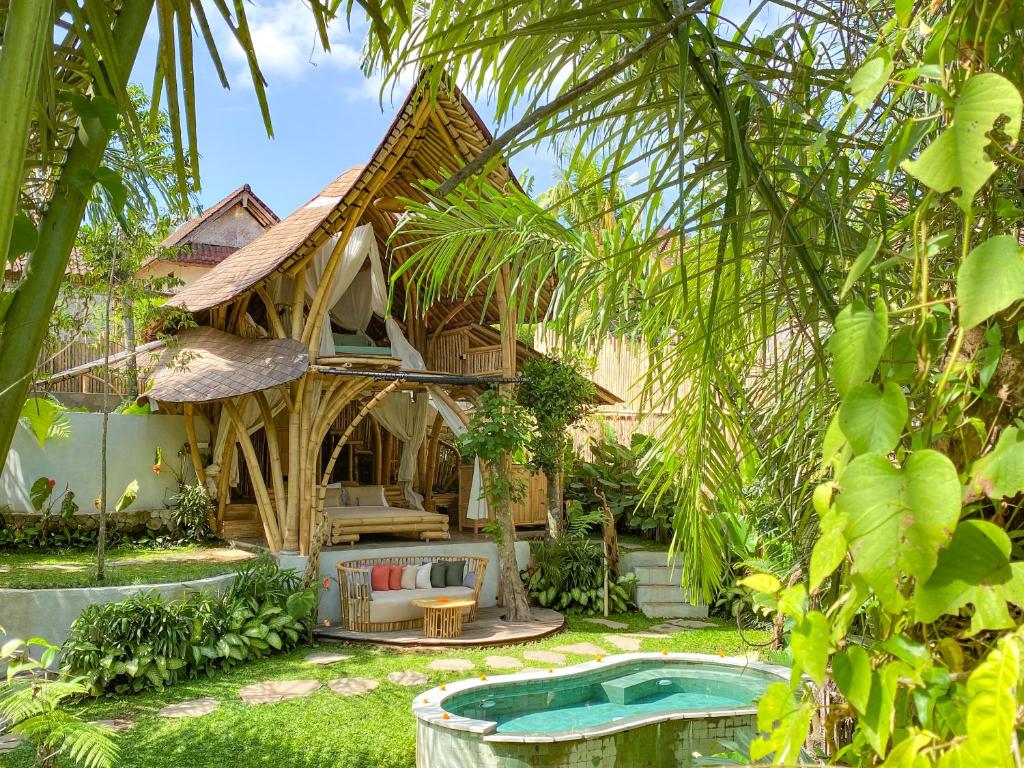 乌布Wahem Eco Bamboo的一座带游泳池的度假村,位于一座房子前