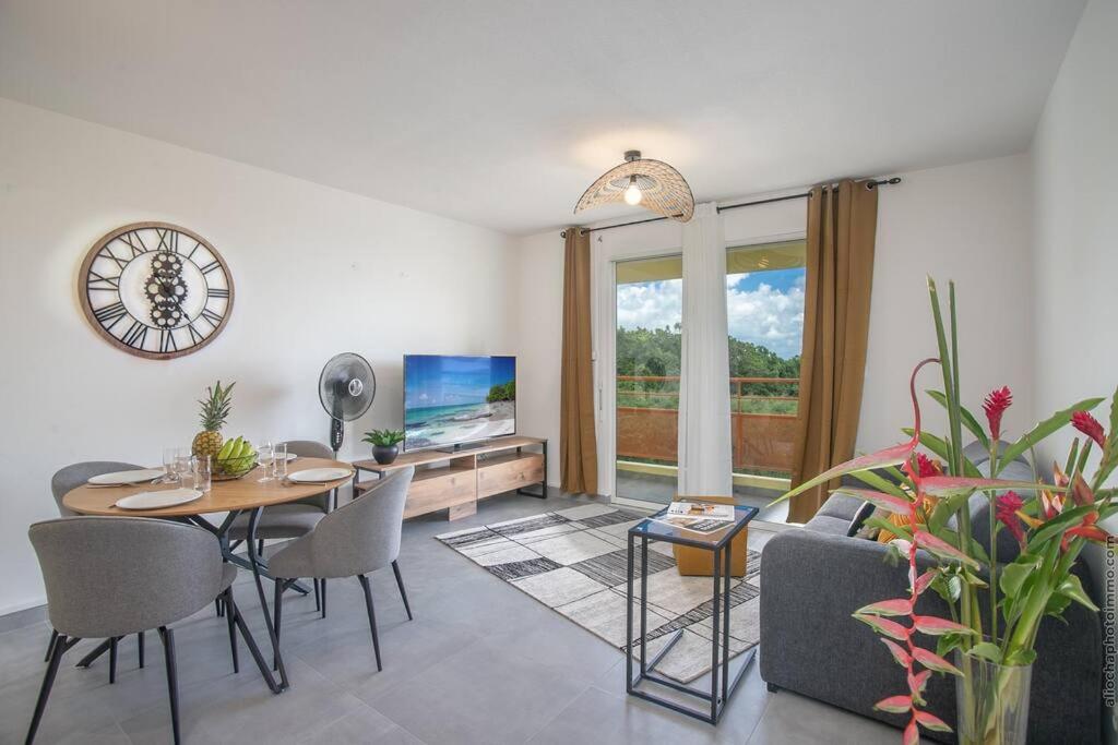 勒拉芒坦Navira - Appartement le Pavillon的客厅配有桌椅和电视。