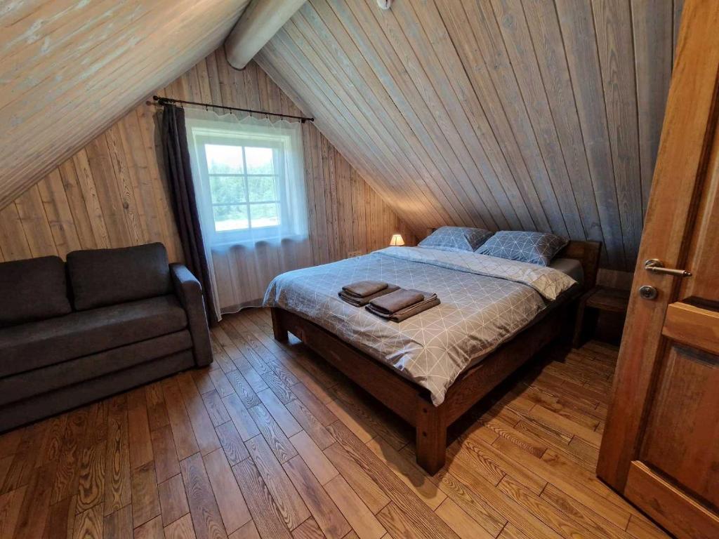 Anykščiai MĖNULIO AKMUO的阁楼上一间卧室配有一张床和一张沙发