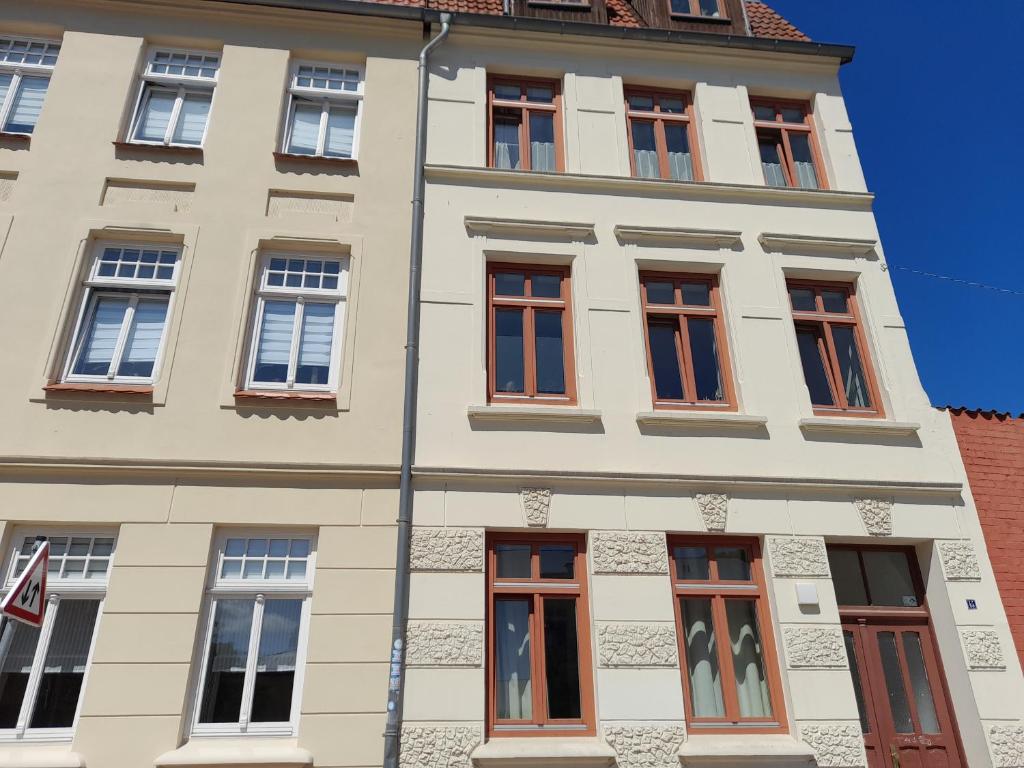 维斯马Kleine Altstadt-Wohnung mit Terrasse的一座高大的白色建筑,有许多窗户