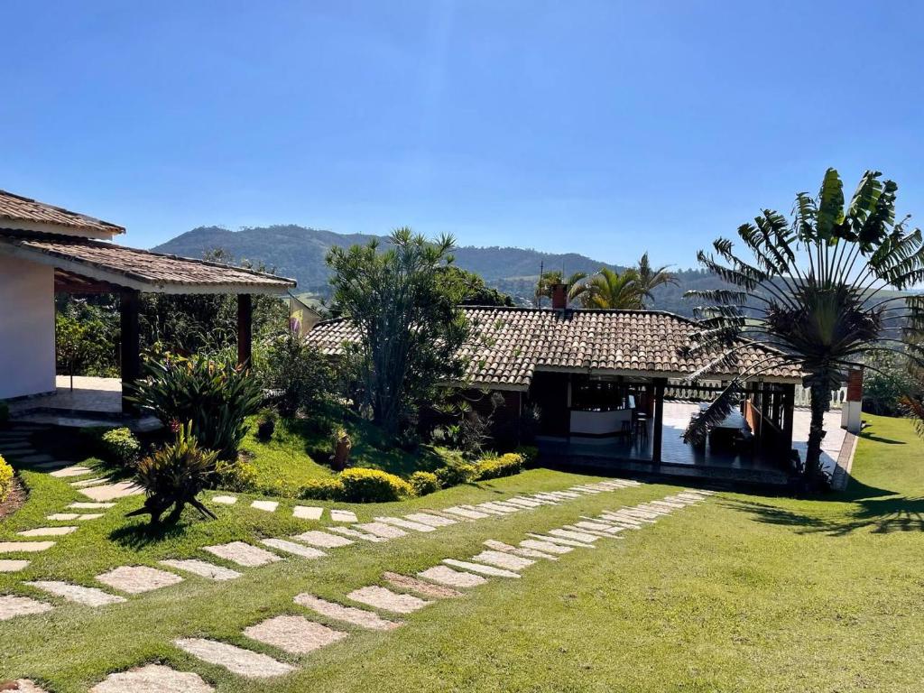 阿蒂巴亚Chácara Mira Flores的一座带草坪的房屋和一座棕榈树的房子