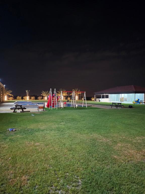 乌姆盖万مزرعة الاسترخاء的一个带长椅的公园和夜间游乐场