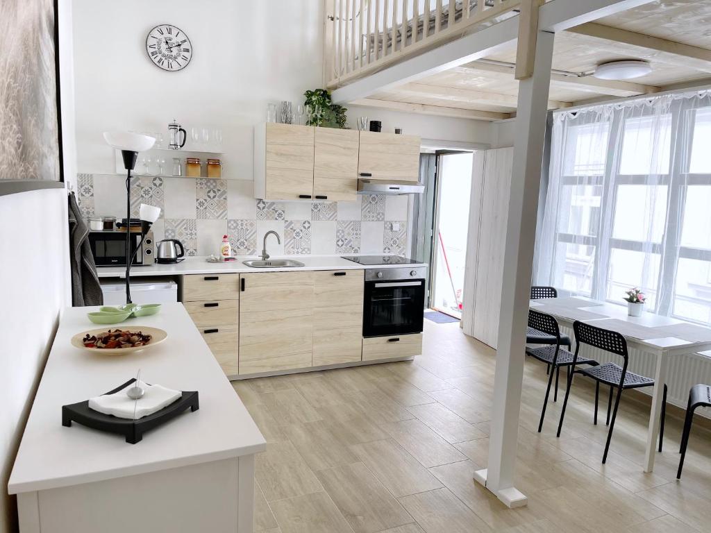 库特纳霍拉Comfortable apartments under the St. Barbara´s Cathedral的厨房配有白色橱柜和桌椅