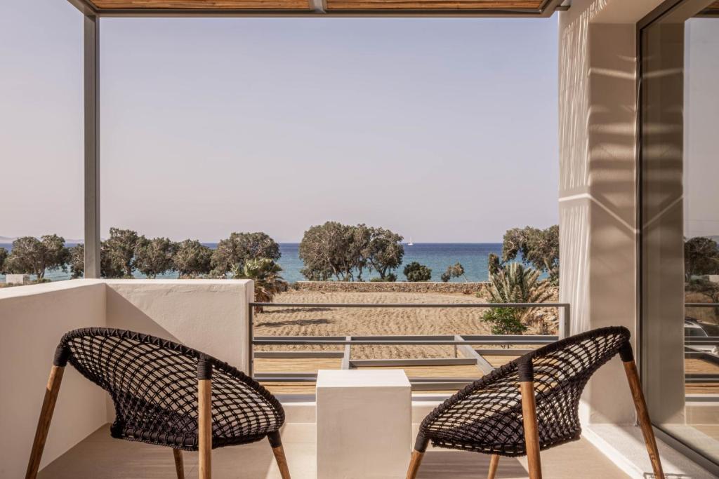 提诺斯Yenesis Seaside Retreat - Adults only的海滩景阳台的两把椅子