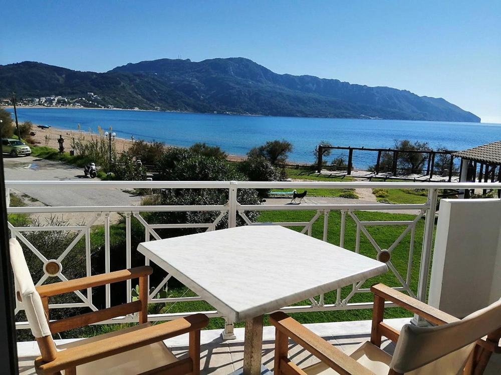 埃费奥纳斯Vrachos Pension的海景阳台上的白色桌椅