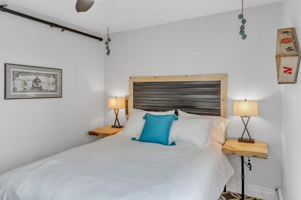 安克雷奇Highliner Hotel - Queen Suites的卧室配有带蓝色枕头的大型白色床