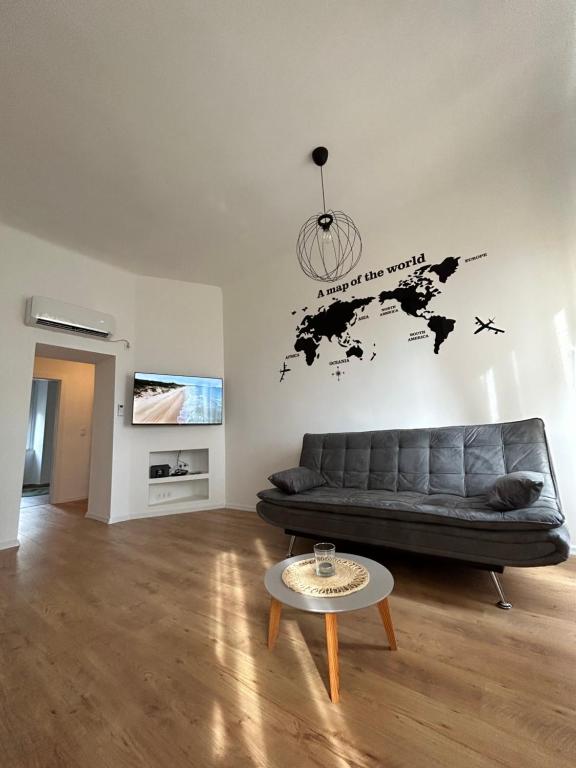 里耶卡Nina & Lola的客厅配有沙发,墙上挂着世界地图