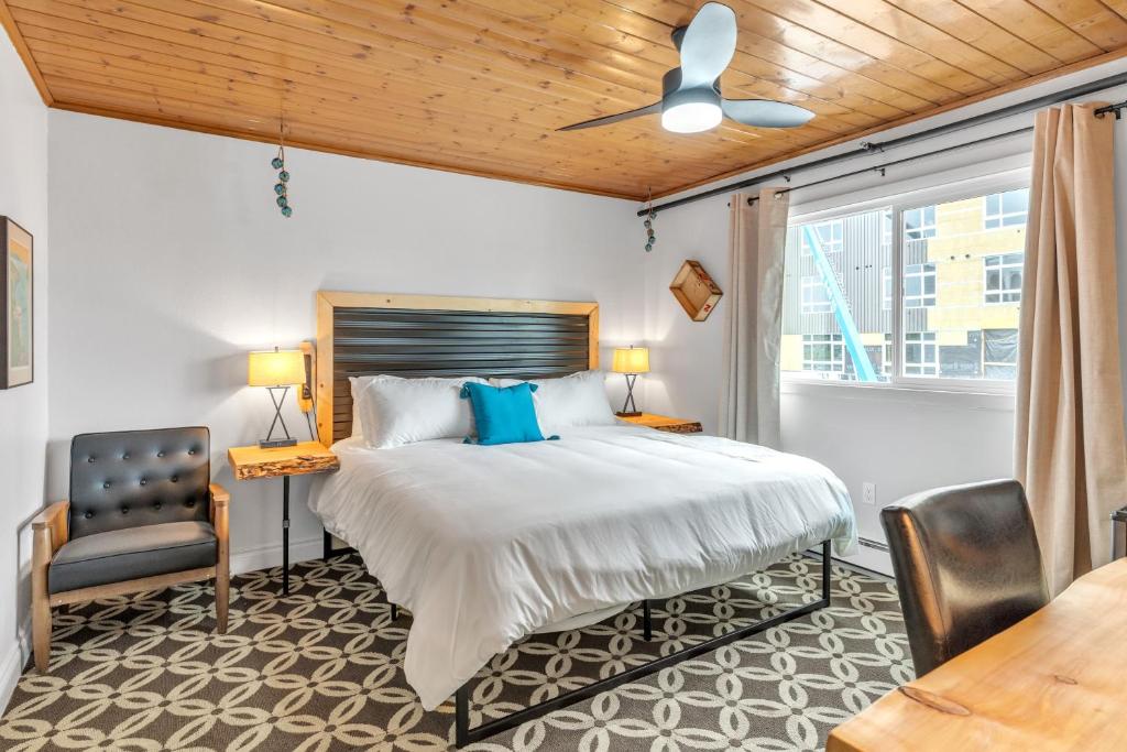 安克雷奇Highliner Hotel - Deluxe King with City View的一间卧室配有一张大床和一把椅子