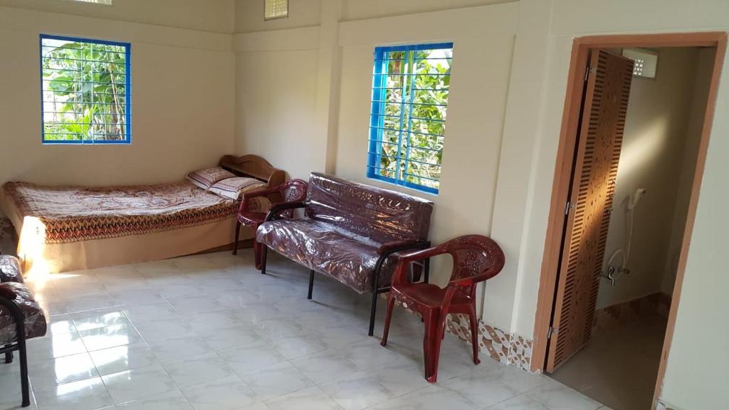 巴纳内拉斯Sunapur Mini Resort Sylhet的客房设有沙发、床和窗户。