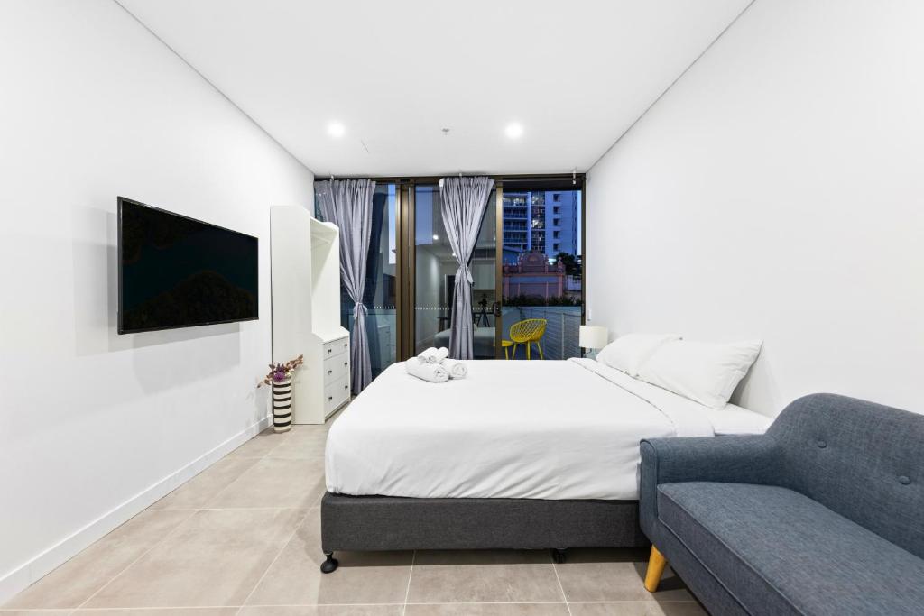 悉尼Arthur's Hotel Bondi Junction的白色卧室配有床和沙发