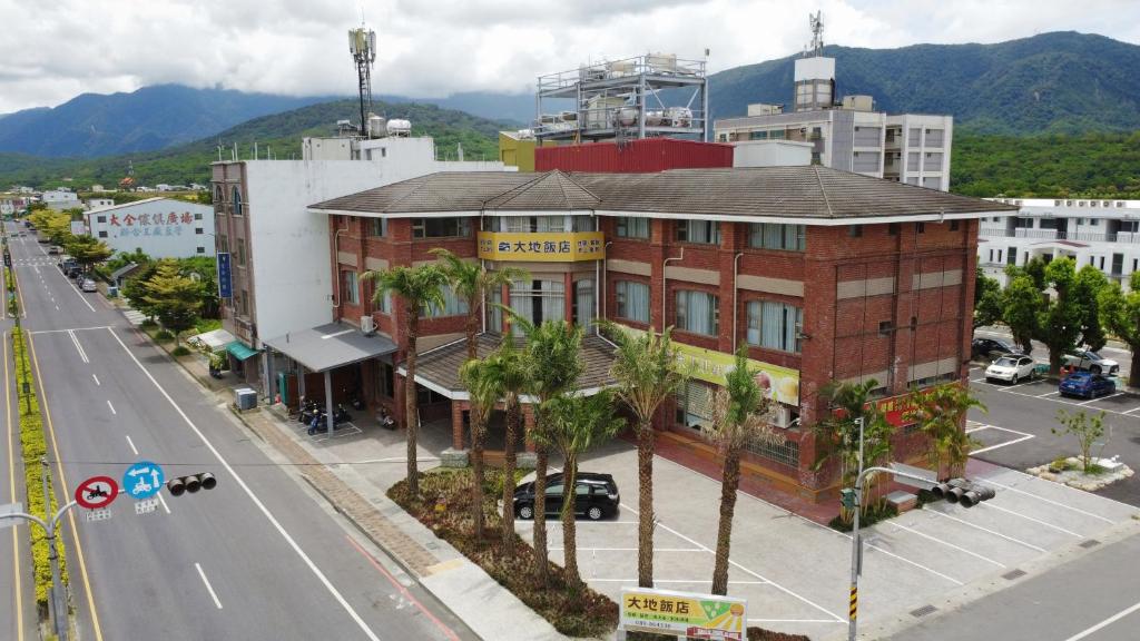 池上池上大地飯店的棕榈树街道边的建筑