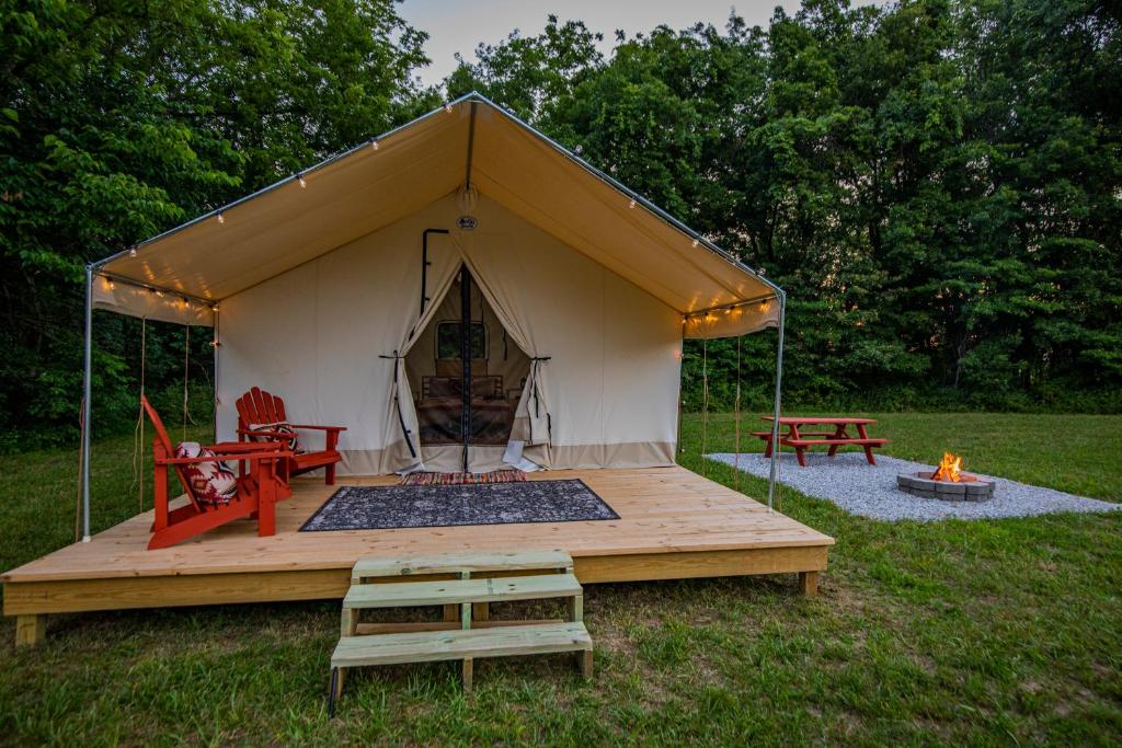 CassvilleRoaring River Luxury Glamping #4的田野上带桌椅的帐篷