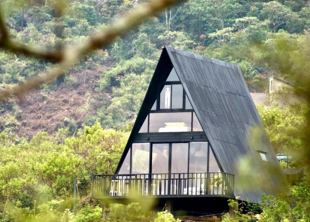 LindulaThe ZenDen-Cozy Cabin Perfect For Couples的山上有黑色屋顶的房子