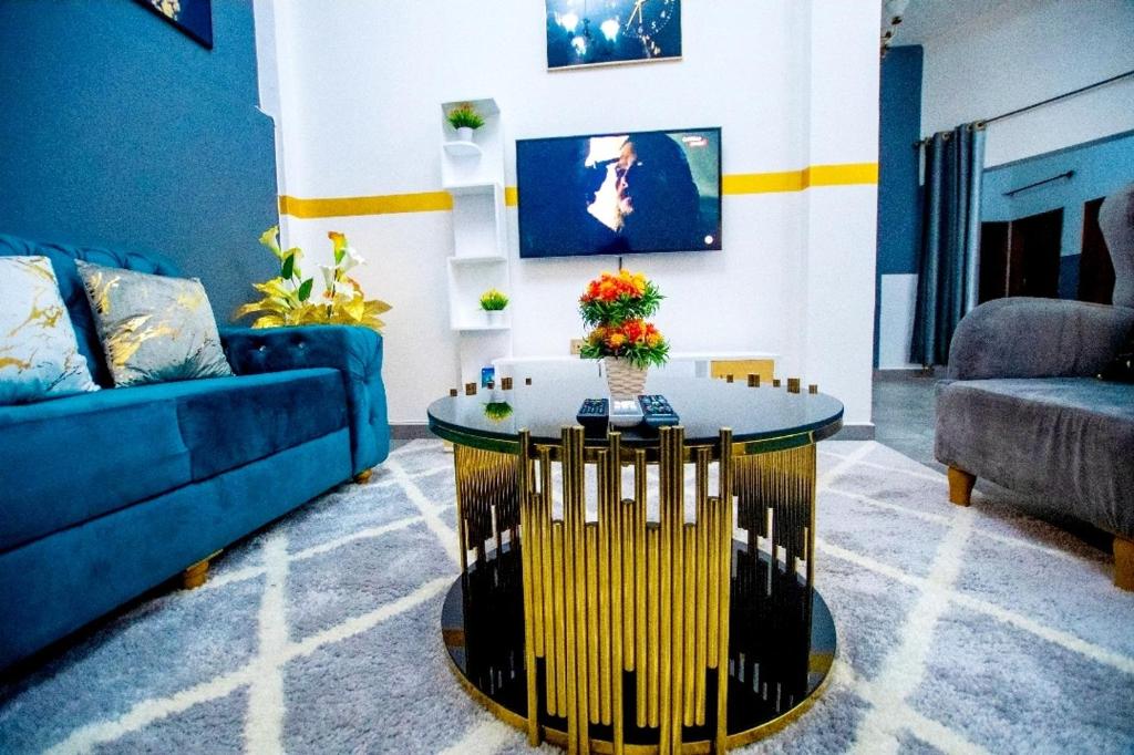 杜阿拉Appartement meublé的客厅配有蓝色的沙发和桌子