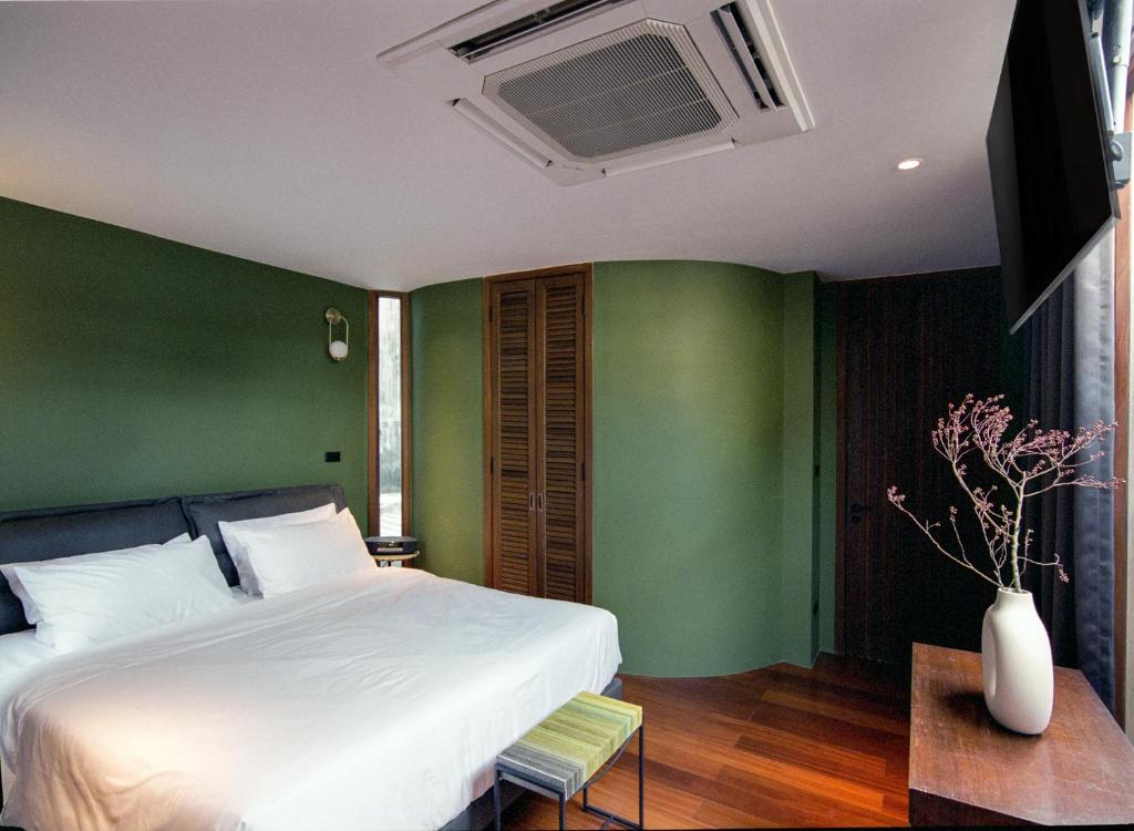 曼谷Na Tanao 1969的卧室配有白色的床和绿色的墙壁