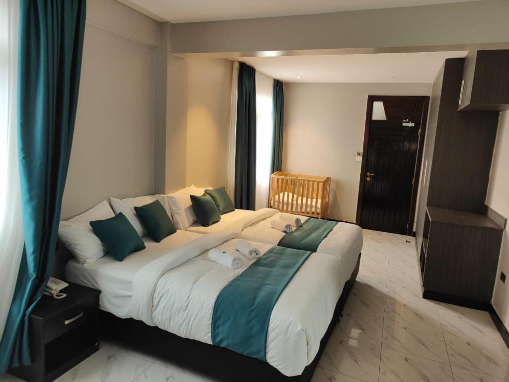 SiayaHotel Lourdes, Siaya的一间卧室配有一张带绿色和白色枕头的大床