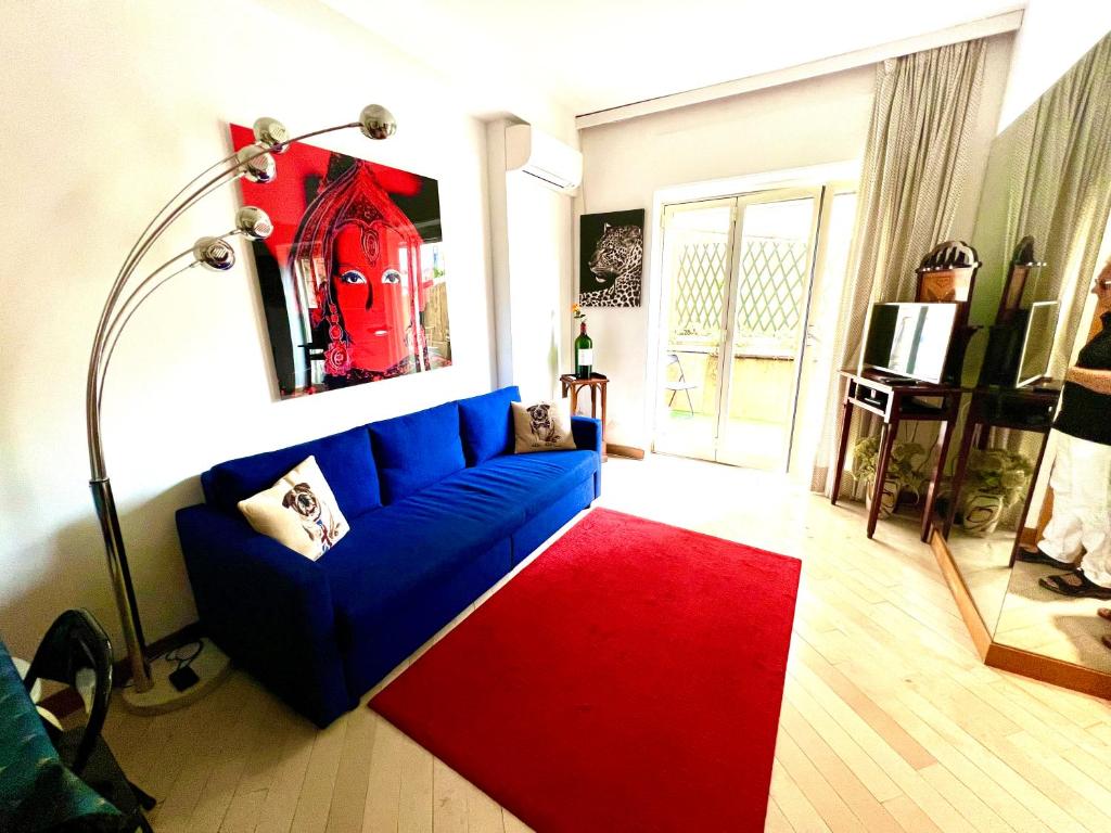 蒙特卡罗Very Central suite apartment with 1bedroom next to train station Monaco and 6min from casino place的客厅配有蓝色的沙发和红色地毯。