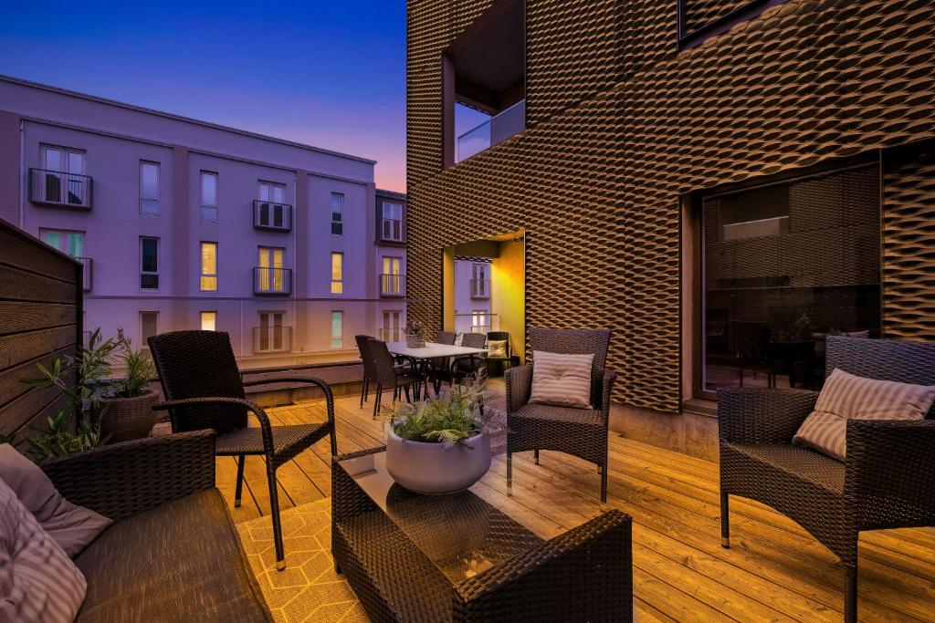 雷克雅未克Venture Vacation-Stunning City Centre Oasis的一个带桌椅的庭院和一座建筑