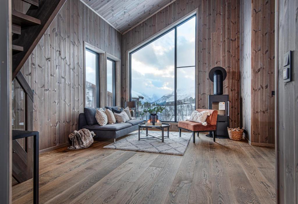 斯特兰达Premium Penthouse near Strandafjellet Ski Resort & Geiranger - Panoramic Mountain Views & Sauna的客厅配有沙发和桌子