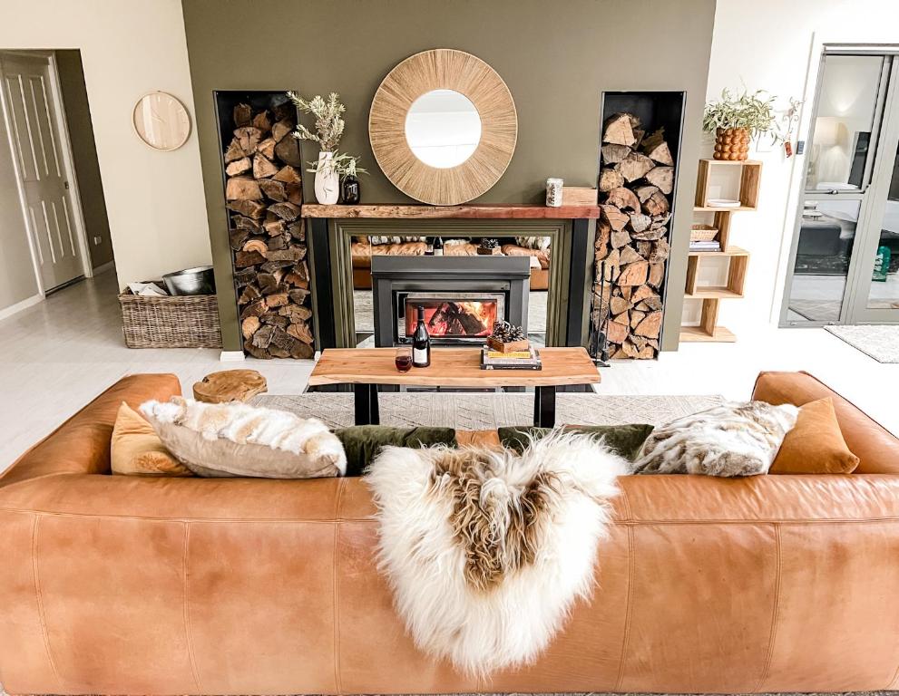 金德拜恩Hamilton House - Snowy Mountain Luxury Villas的客厅设有棕色沙发和壁炉