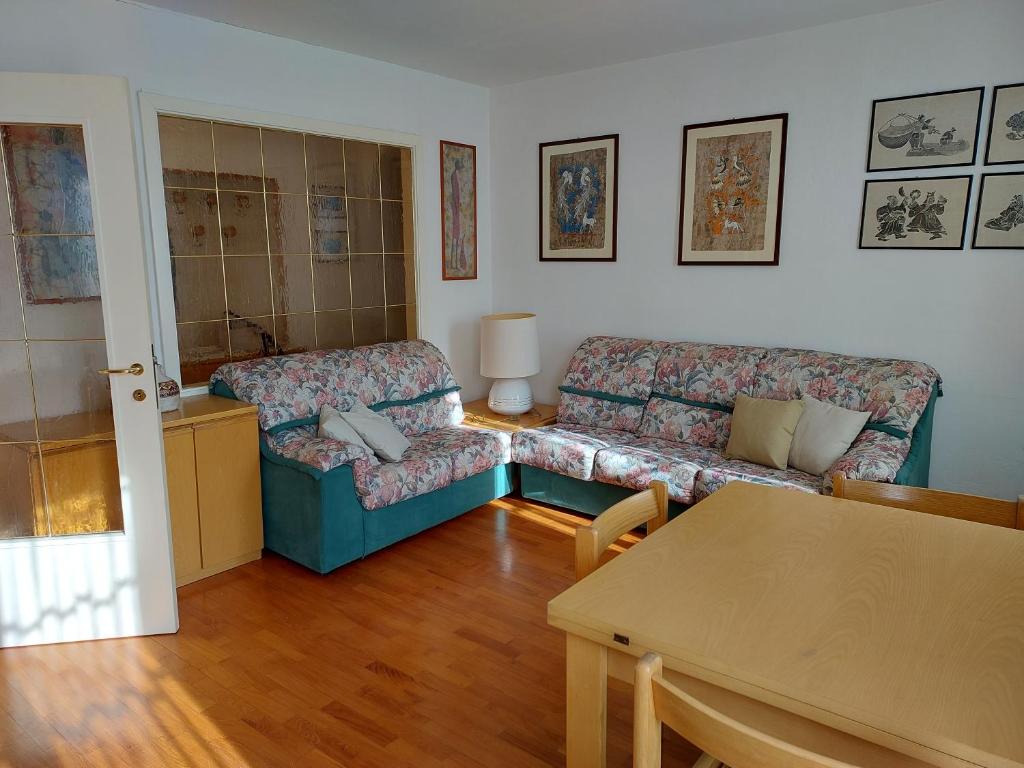 罗韦雷托Appartamento Gisella的客厅配有沙发和桌子