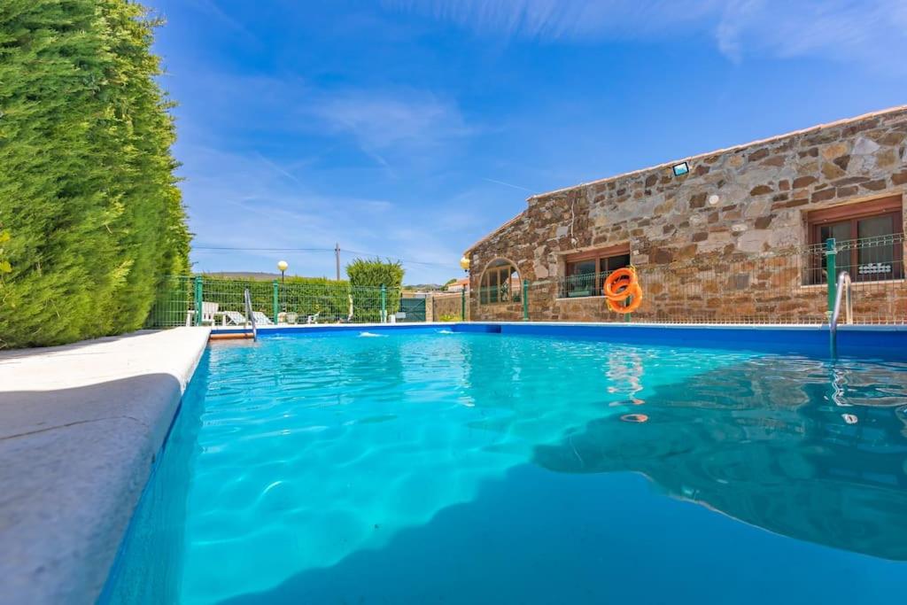 塔里法Chalet con piscina privada en Bolonia的大楼前的蓝色海水游泳池