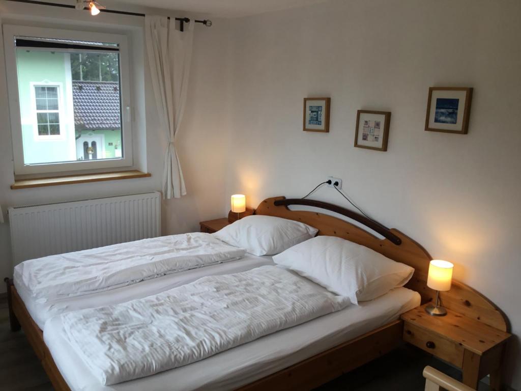 马特塞Haus Schmid Mattsee的一间卧室配有一张床、一个窗口和两盏灯。