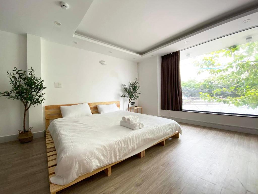 胡志明市J&K Hotel的一间卧室设有一张大床和一个大窗户