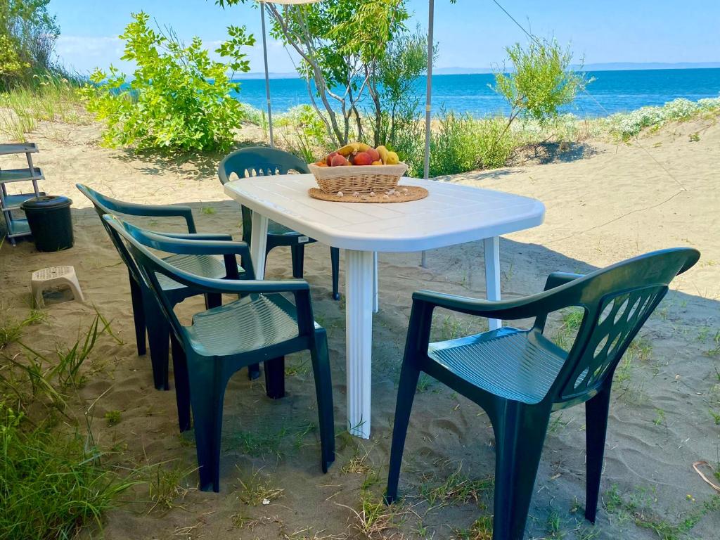 切尔诺莫雷茨Beachfront Caravans - Meadow Camp的一张桌子,有四把椅子和一碗水果