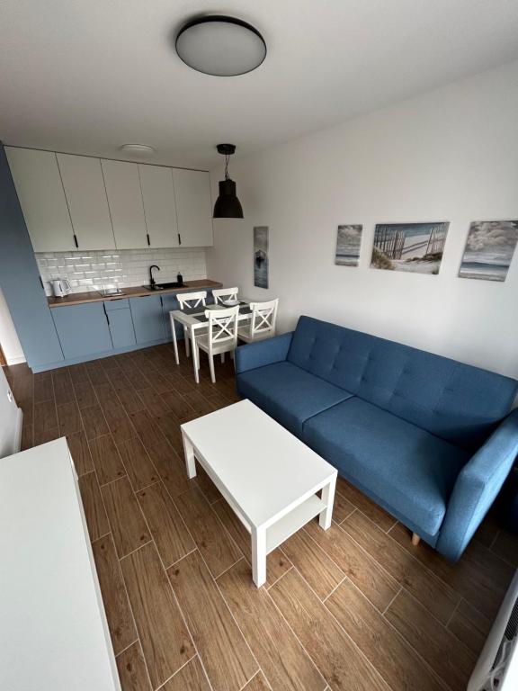 罗威Apartament za wydmami的客厅配有蓝色的沙发和桌子