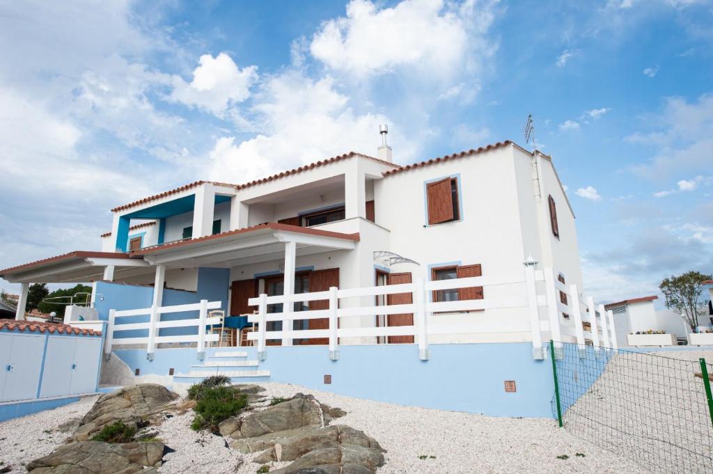 托雷戴科尔萨里Villa la Torre Libeccio的海滩上的白色房屋,带围栏